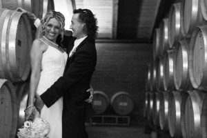 bride groom smile winery barrels hug